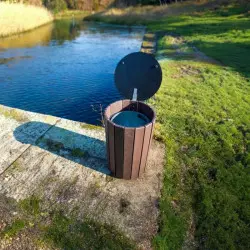 Poubelle collectivité avec couvercle près d'un plan d'eau
