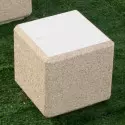 Banc en béton blanc, cube posé sur l'herbe