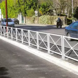 Barrières urbaines en acier blanc alignées le long d'un trottoir