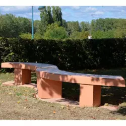 Banc courbe sans dossier en béton dans une aire de repos
